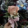 Single peach rose boutonniere with baby's breath and pink ribbon