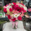 Pink and white bouquet of roses and daisies with a butterfly pick