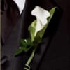 White calla lily boutonniere on a dark suit lapel