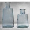 Two blue glass vases on a gray surface
