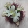 White orchid and rose corsage with burgundy ribbon accents