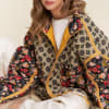Woman wearing a patterned floral quilted jacket over a white top