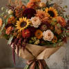 Bouquet of sunflowers, dahlias, and roses wrapped in brown paper