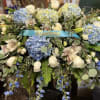 Large blue and white floral arrangement with a blue ribbon