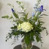 This simple but elegant arrangement has hydrangea, Iris, snapdragons, delphinium and more.