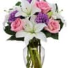 Pink roses and white lilies in a clear glass vase