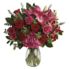 Bouquet of pink lilies and red roses in a clear glass vase