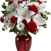 Red roses and white lilies in a red glass vase