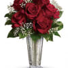 Red roses in a silver vase with white baby's breath