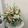 Mixed floral arrangement with peach roses, gerbera daisy, and hydrangea in a vase