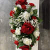Red and white floral arrangement with roses, carnations, and baby's breath