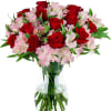 Red roses and pink alstroemeria in a clear glass vase