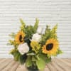 Sunflowers and white roses in a glass vase with yellow filler flowers