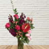 Mixed bouquet in a glass vase with pink roses and red anthurium