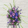 Tall purple and lavender floral arrangement with roses and blue blooms