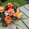 Bouquet of orange roses and peach carnations with greenery