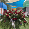 Large red rose arrangement with white filler flowers and palm fronds
