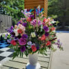 Large mixed floral arrangement in a white pedestal vase