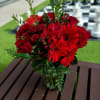 Red mixed flower bouquet in a glass vase