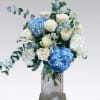 A stunning bouquet of white roses, blue and white hydrangeas, and eucalyptus