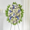 Standing floral spray of white and blue flowers on an easel