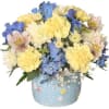 Bouquet of yellow, blue, and white flowers in a light blue vase