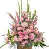 Pink and peach floral arrangement in a woven basket