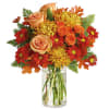 Autumn bouquet of roses and daisies in a clear glass vase