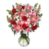 Bouquet of pink lilies and red roses in a glass vase