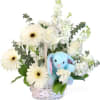 White flowers in a basket with a blue plush bunny