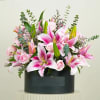 Pink lilies and roses arranged in a black box