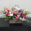 Mixed pink and white flower arrangement in a wooden box