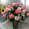 Pink roses in a clear glass vase with baby's breath