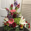Colorful mixed flower arrangement in a wooden box with lilies and roses