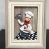 Framed chef figurine holding a serving tray