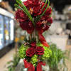 Tall arrangement of red roses with green accents and red ribbon