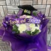 Purple bouquet with roses and a graduation topper