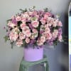 Large pink and lavender flower arrangement of roses and carnations in a lavender hat box container