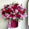Large pink and red rose arrangement with mums in a deep pink hatbox container