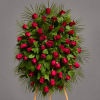 Standing spray of red roses with palm fronds on a gray background