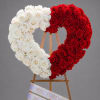 Heart-shaped rose arrangement in red and white on a wooden easel