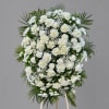 White floral standing spray with roses and daisies on an easel