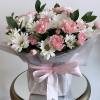 Delicate shades of pink and white daisies and carnations are beautifully arranged