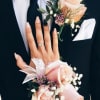 Man in a suit with a rose boutonniere and matching wrist corsage