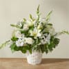 White floral arrangement in a woven basket with lilies, roses, and daisies