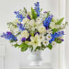 White and blue floral arrangement in a white vase