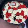 Round bouquet of red and white roses in black wrapping