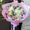 Pink and white bouquet with roses and carnations wrapped in pink paper