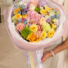 Pastel mixed bouquet with roses, carnations, and daisies wrapped in pink paper