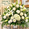 White lilies, roses, and mums arranged in a white vase